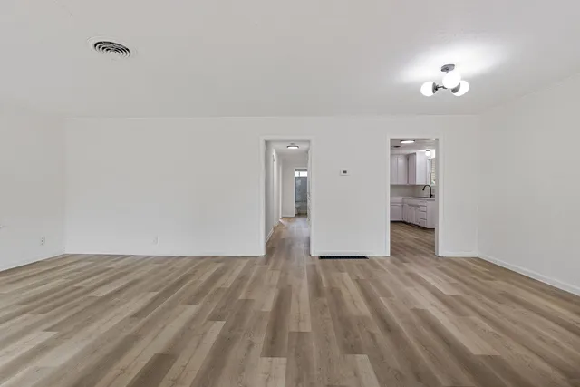 a view of a livingroom with wooden floor and a ceiling fan