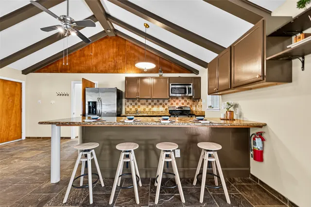 a kitchen with a sink and chairs