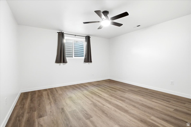 1676 East 11245 South Sandy, UT 84092 - Photo 26 of 34 Spacious room featuring wood-finish flooring, white baseboards, and a modern ceiling fan with integrated lighting