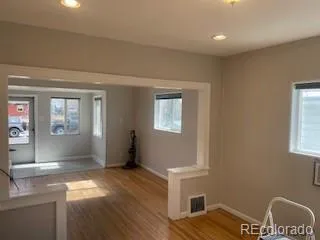 a view of livingroom with hardwood floor and a kitchen