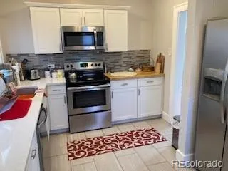 a kitchen with stainless steel appliances granite countertop a stove a microwave and a refrigerator