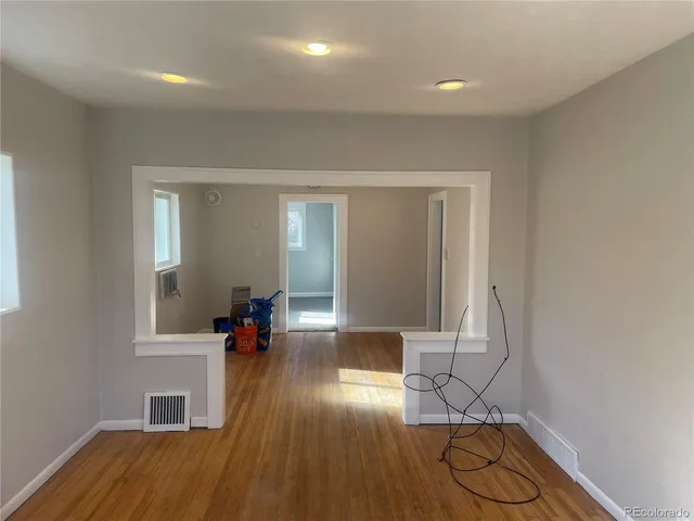 a hallway with wooden floor and furniture
