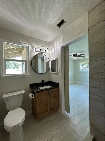 a view of a room with wooden floor and a ceiling fan