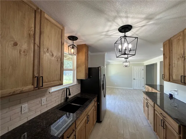 a kitchen with stainless steel appliances a refrigerator a sink a stove a microwave and island