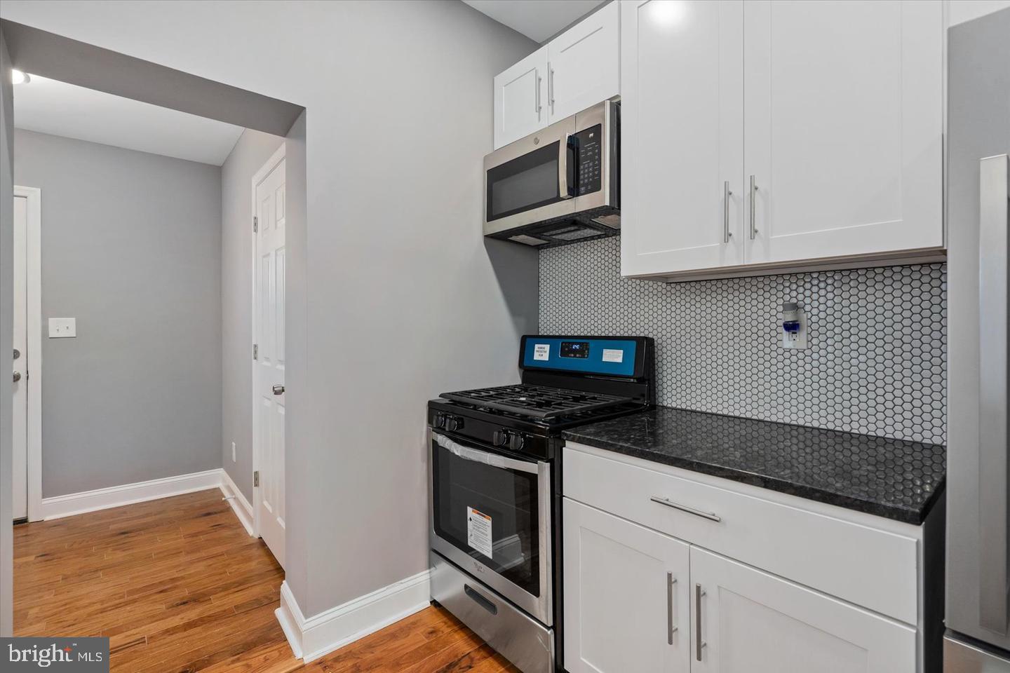 327 Lyndhurst Street Baltimore, MD 21229 - Photo 18 of 44 a kitchen with stainless steel appliances granite countertop white cabinets and a stove