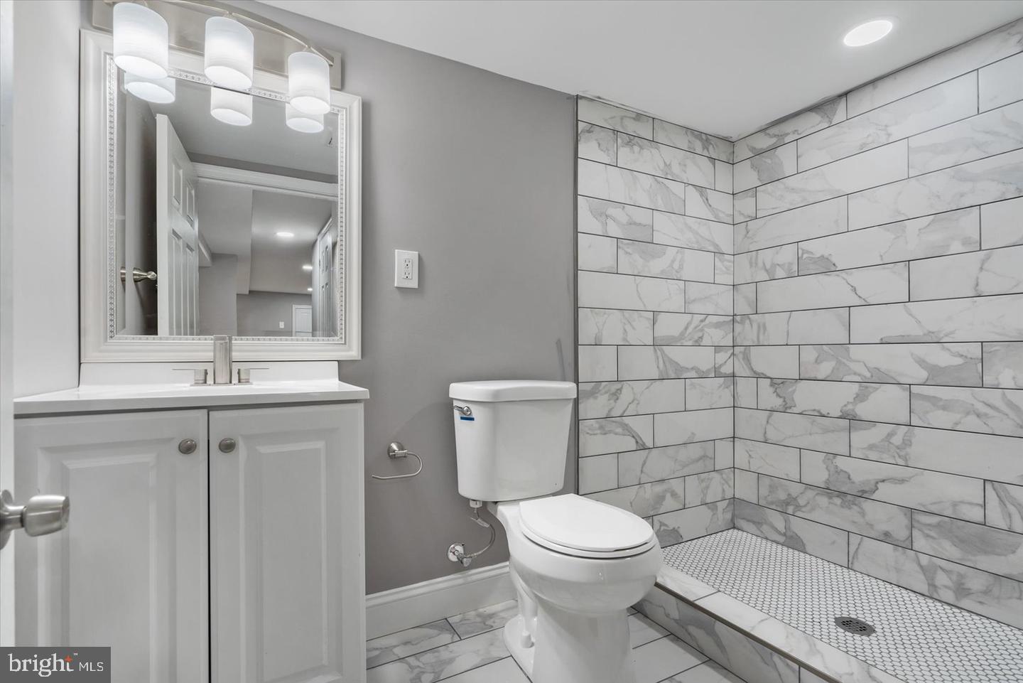 327 Lyndhurst Street Baltimore, MD 21229 - Photo 35 of 44 a bathroom with a toilet a sink a shower and a mirror