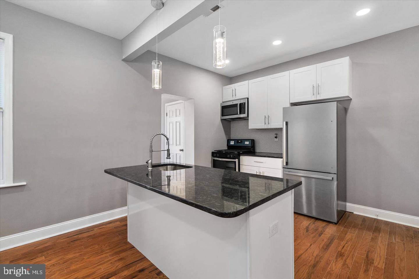 327 Lyndhurst Street Baltimore, MD 21229 - Photo 5 of 44 a kitchen with kitchen island a sink and refrigerator