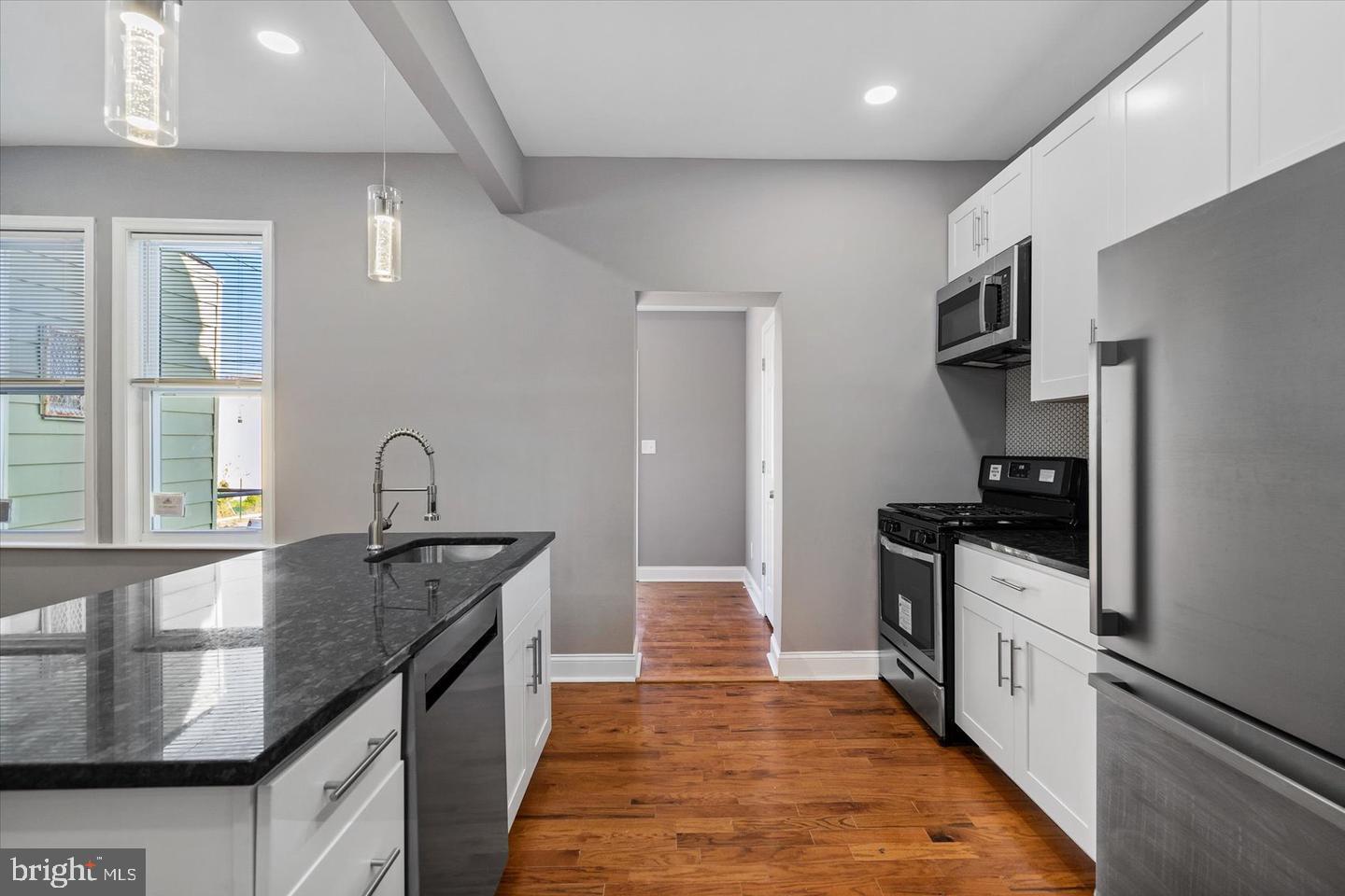 327 Lyndhurst Street Baltimore, MD 21229 - Photo 6 of 44 a kitchen with granite countertop stainless steel appliances a sink stove and refrigerator