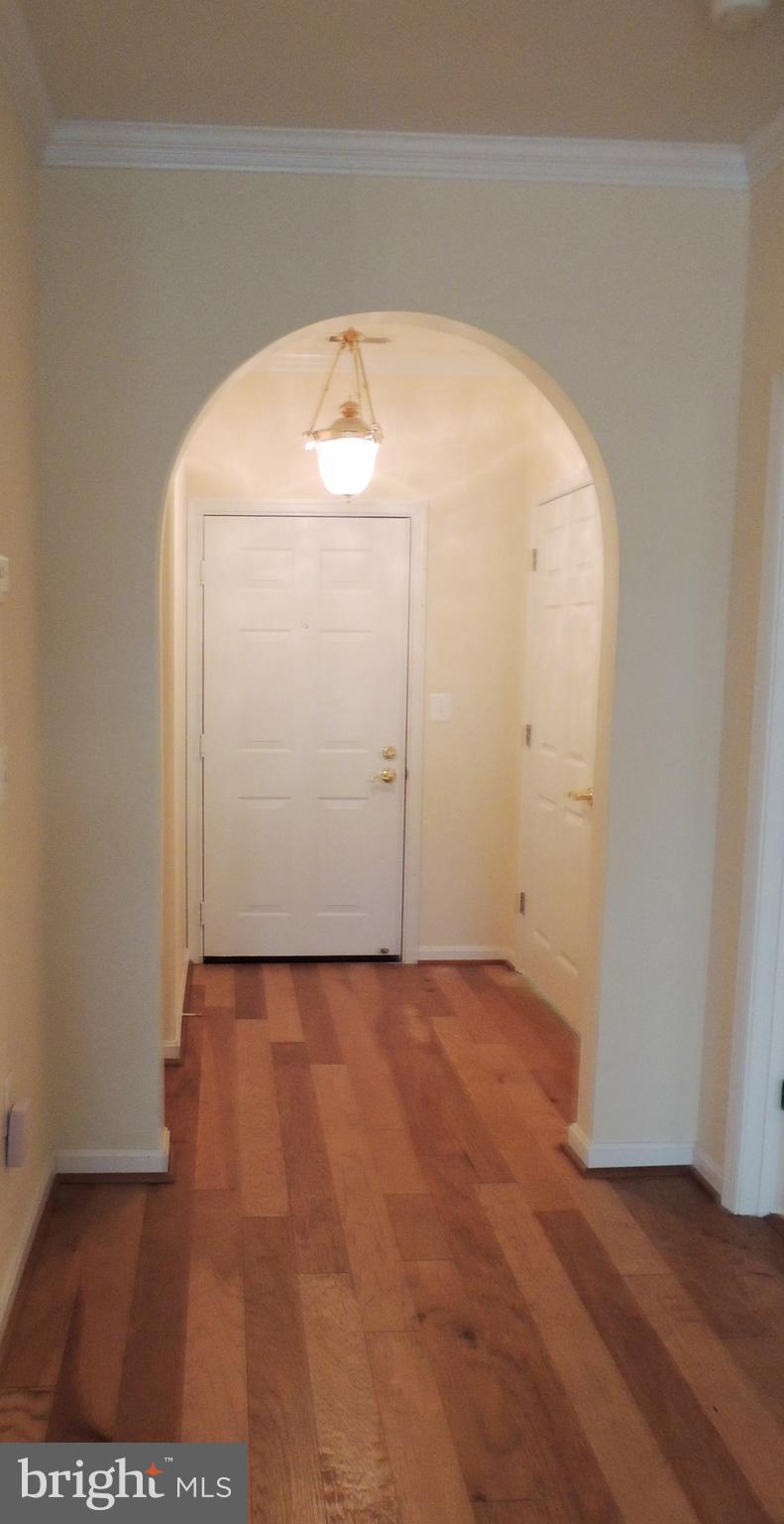 901 Spinnaker Way, Unit 901 Solomons, MD 20688 - Photo 6 of 13 an empty room with wooden floor and mirror