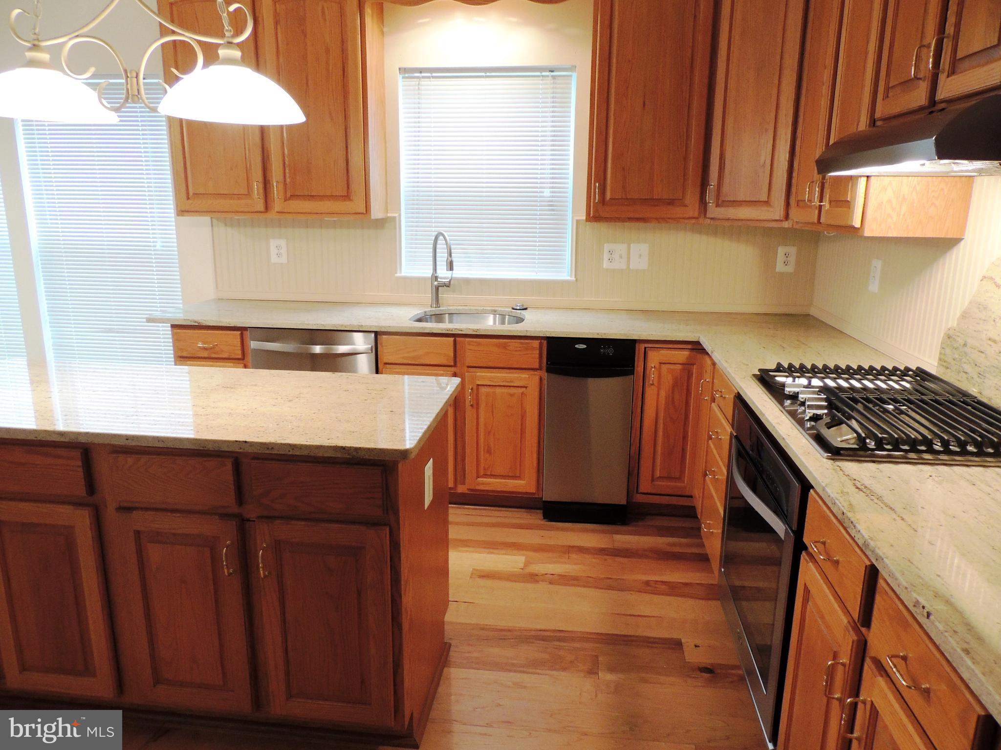 901 Spinnaker Way, Unit 901 Solomons, MD 20688 - Photo 8 of 13 a kitchen with stainless steel appliances granite countertop a sink stove and cabinets