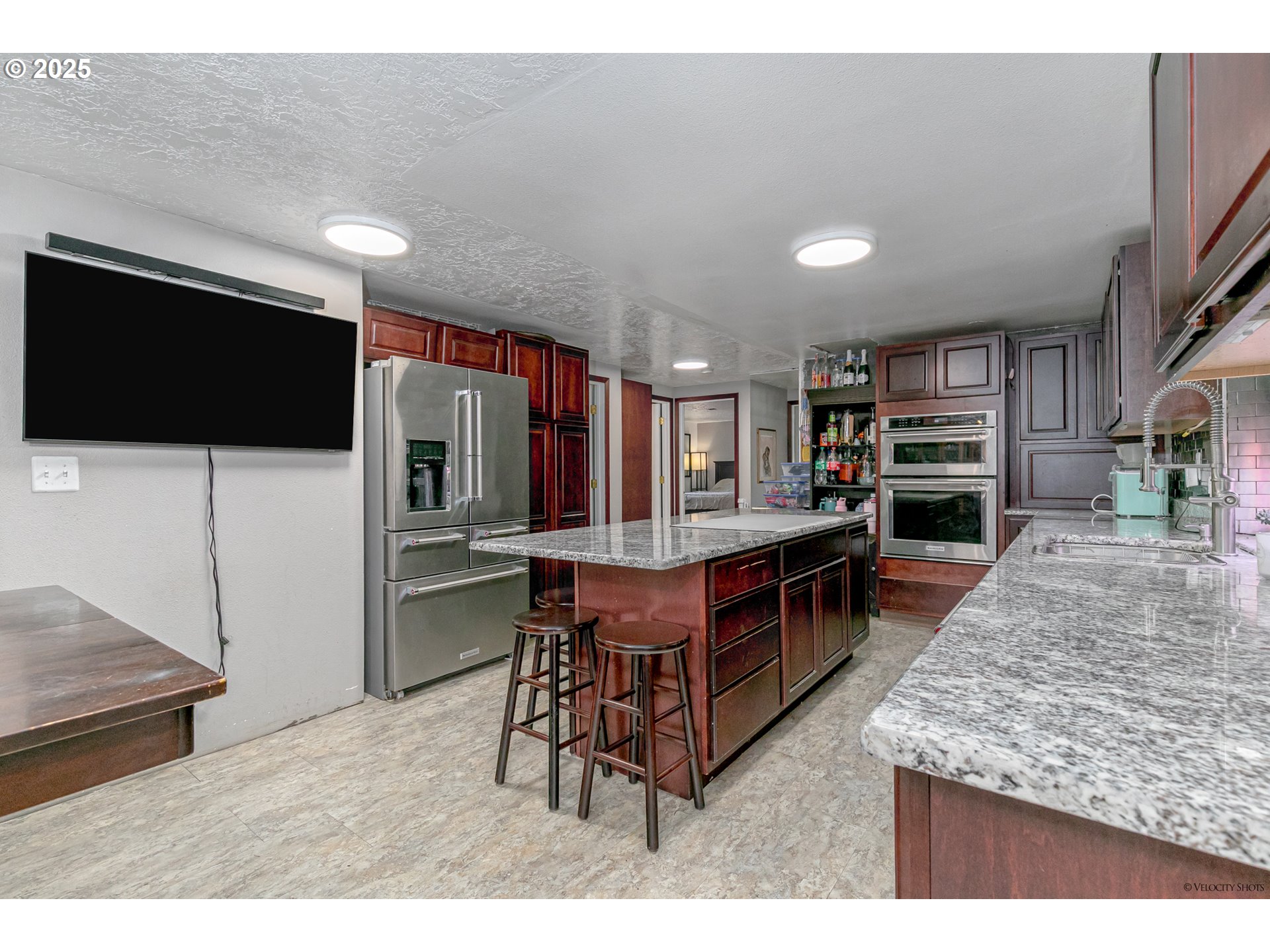 38289 Southeast Coupland Road Estacada, OR 97023 - Photo 12 of 48 a kitchen with stainless steel appliances kitchen island granite countertop a table chairs in it and wooden floors