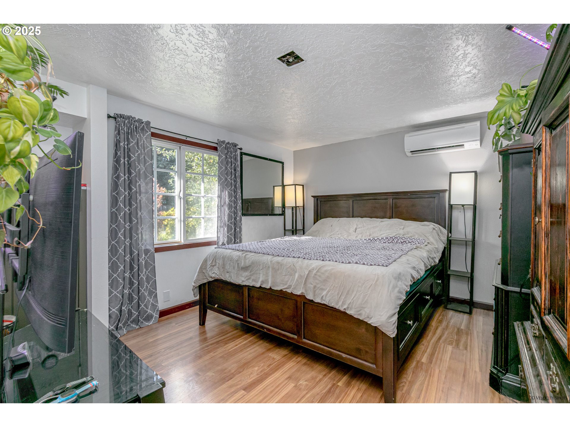 38289 Southeast Coupland Road Estacada, OR 97023 - Photo 18 of 48 a spacious bedroom with a bed and a flat tv screen on dresser