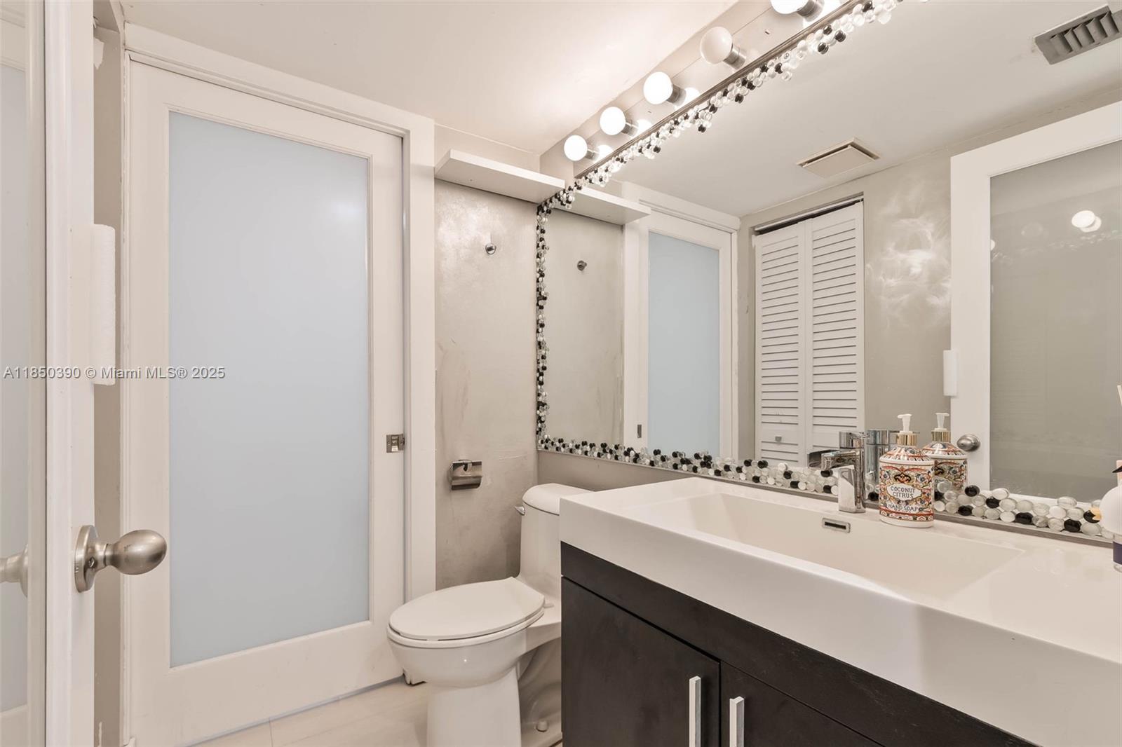 1000 Quayside Terrace, Unit 308 Miami, FL 33138 - Photo 17 of 28 a bathroom with a sink double vanity and a toilet