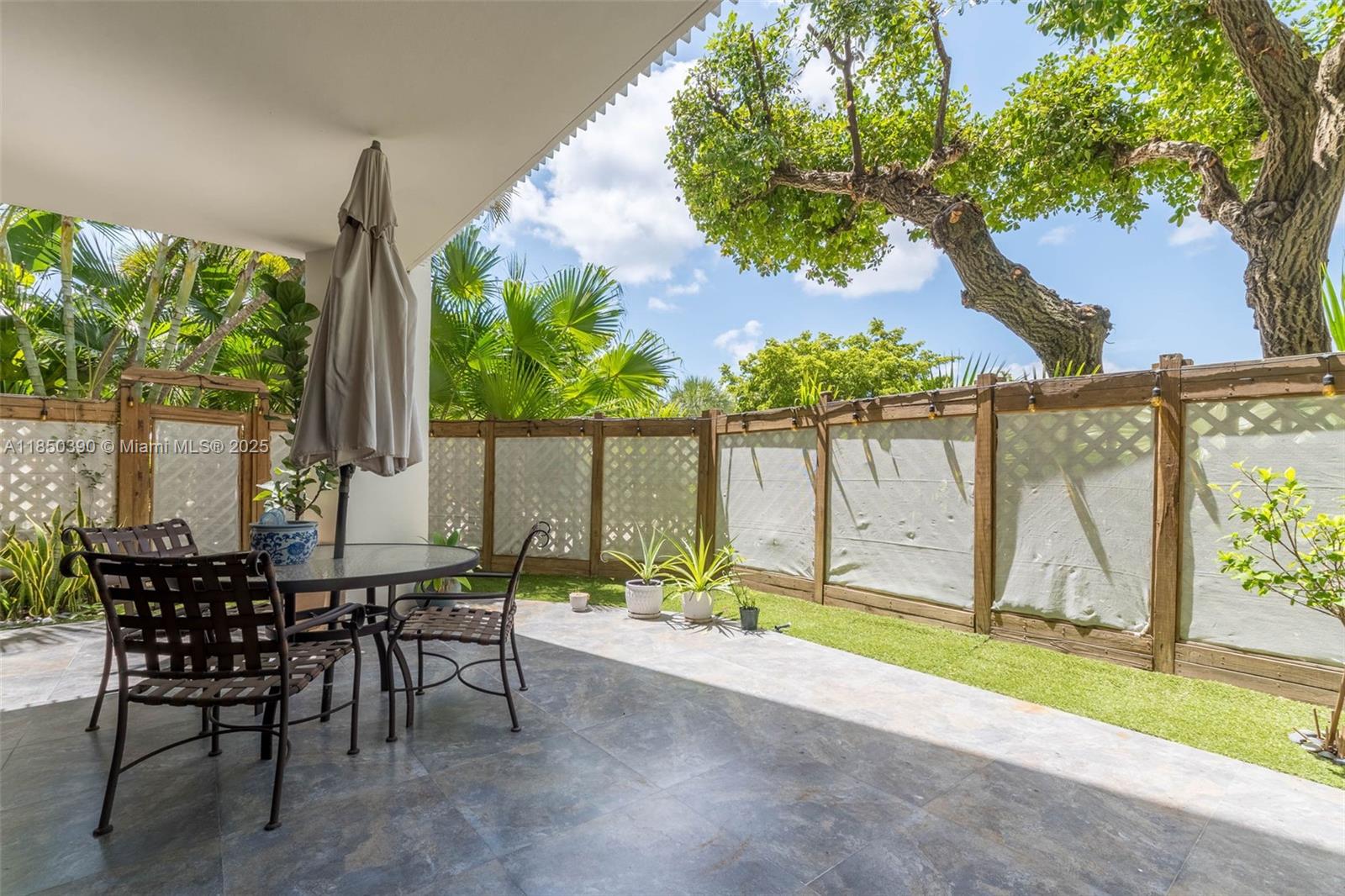1000 Quayside Terrace, Unit 308 Miami, FL 33138 - Photo 3 of 28 a backyard of a house with table and chairs