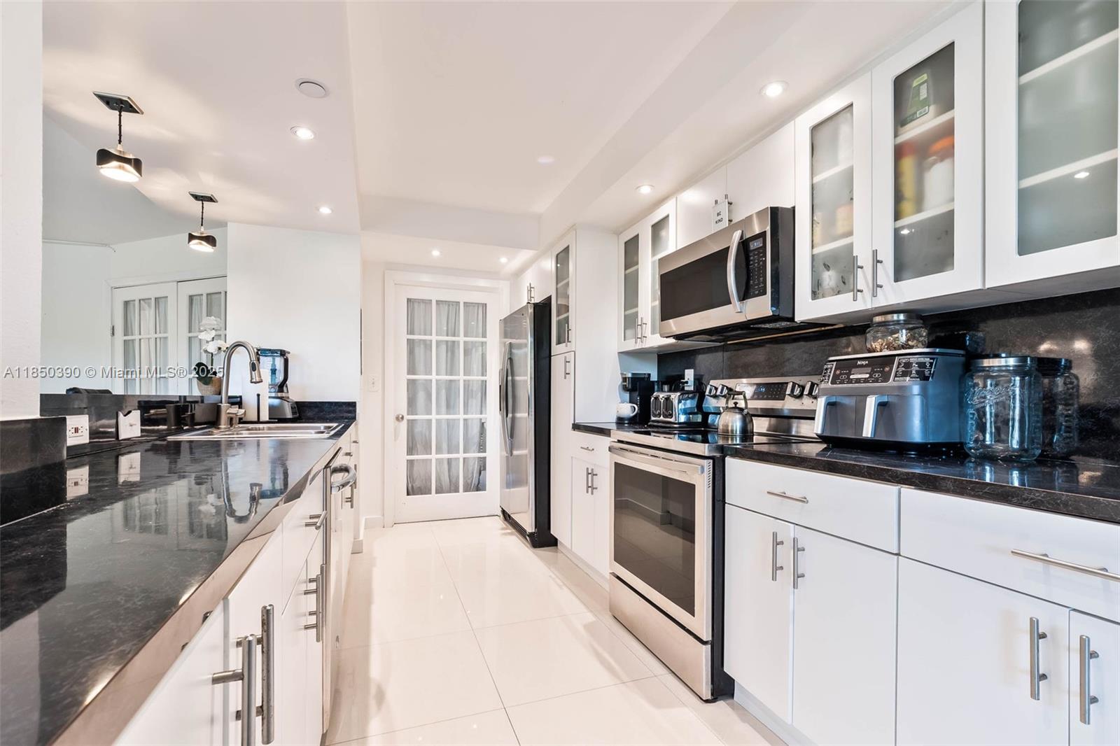 1000 Quayside Terrace, Unit 308 Miami, FL 33138 - Photo 7 of 28 a kitchen with stainless steel appliances granite countertop a lot of counter space and cabinets