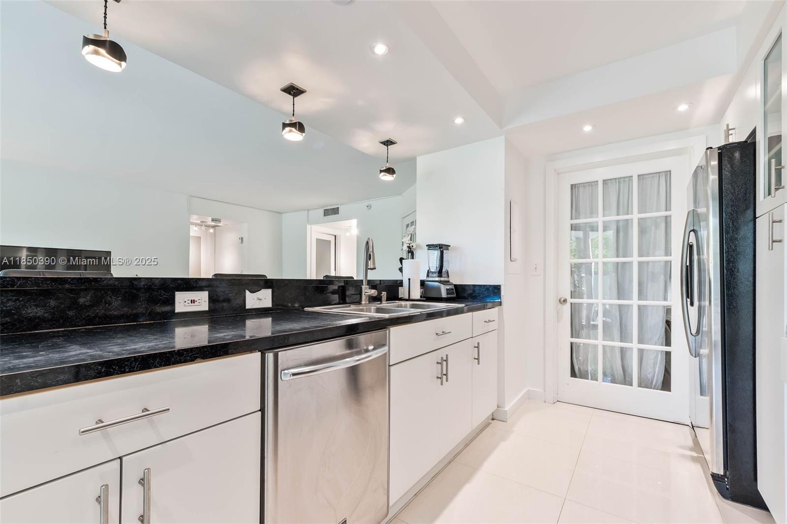 1000 Quayside Terrace, Unit 308 Miami, FL 33138 - Photo 9 of 28 a large kitchen with granite countertop a sink and white cabinets