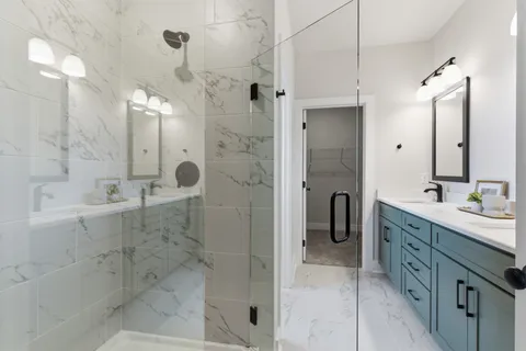 a bathroom with a double sink shower and a mirror
