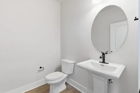 a bathroom with a sink a toilet and a mirror