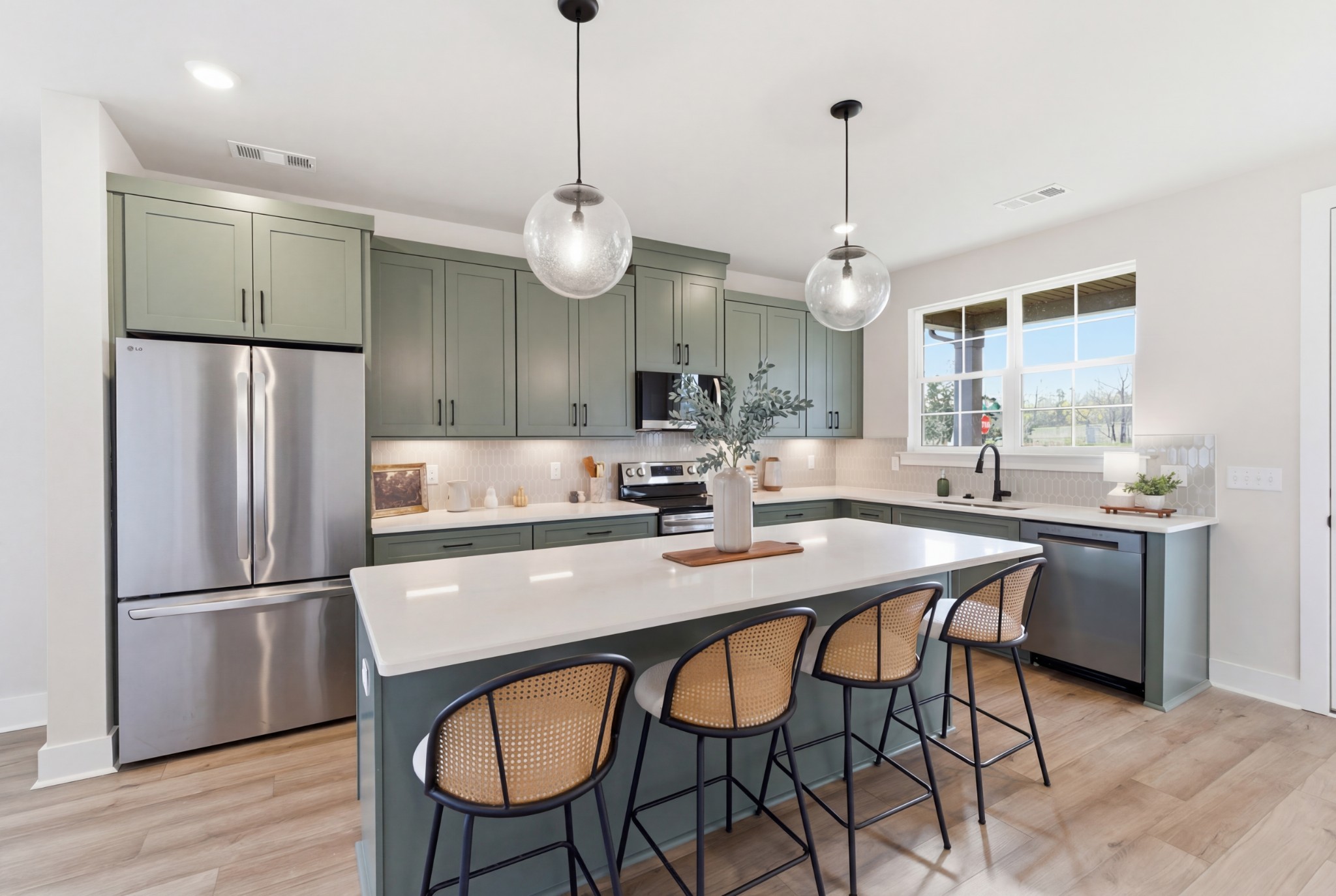 1809 Flatwaters Street Spring Hill, TN 37174 - Photo 7 of 27 a kitchen with stainless steel appliances granite countertop a dining table chairs refrigerator and wooden cabinets