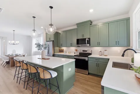 a kitchen with a dining table chairs sink and stove