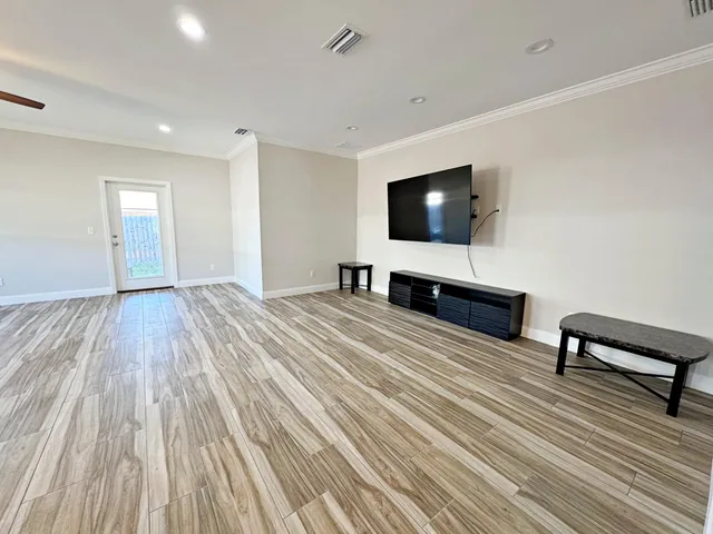 a view of a livingroom with wooden floor and a flat screen tv