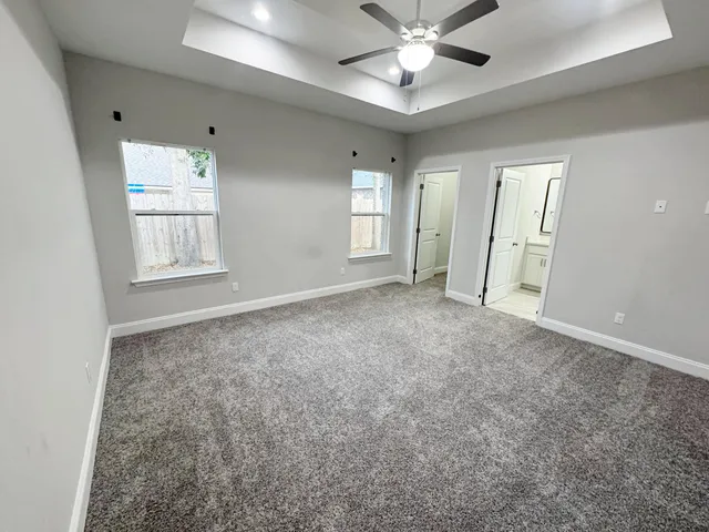 an empty room with windows and fan