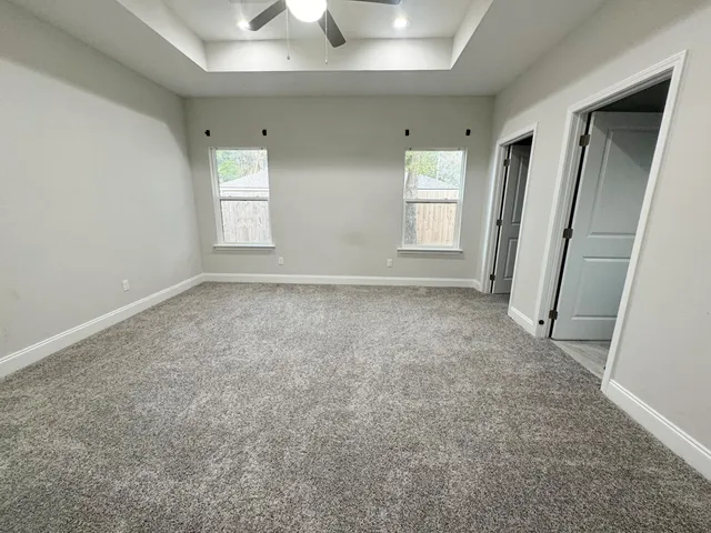 an empty room with windows and closet