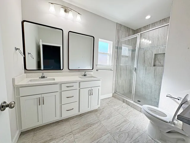 a bathroom with double sink and a mirror