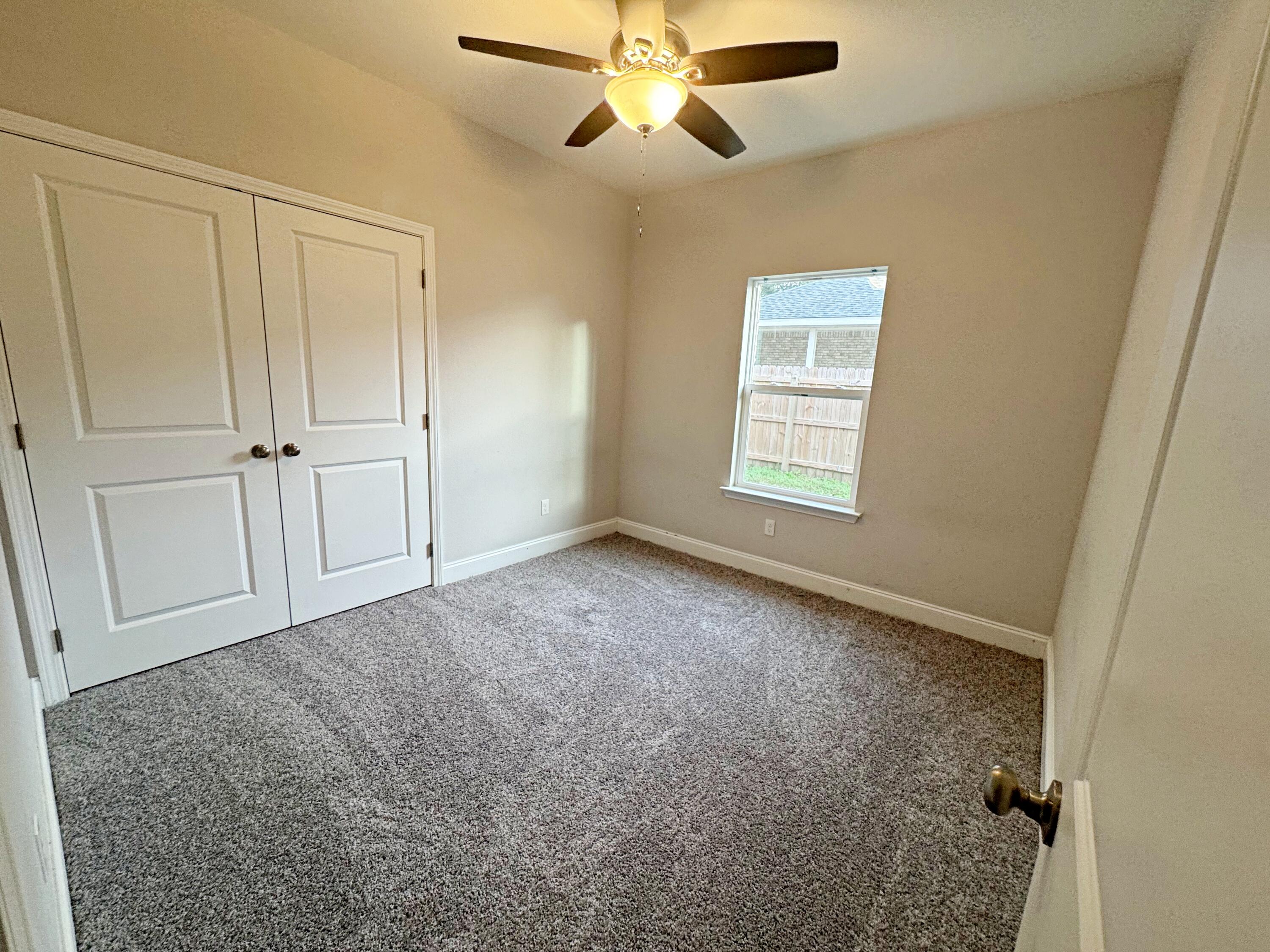 420 Little John Road Mary Esther, FL 32569 - Photo 24 of 37 a view of an empty room and window with a ceiling fan