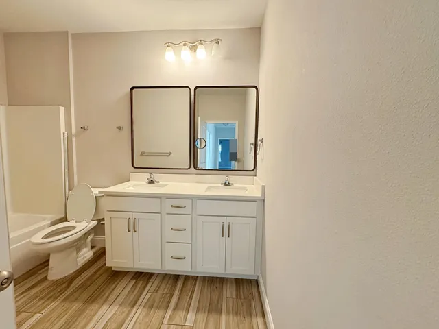 a bathroom with a sink mirror vanity and toilet