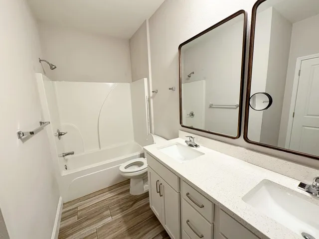 a bathroom with a double vanity sink mirror double and bathtub