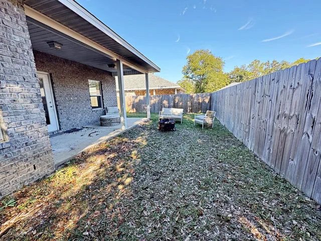 a backyard of a house with table and chairs