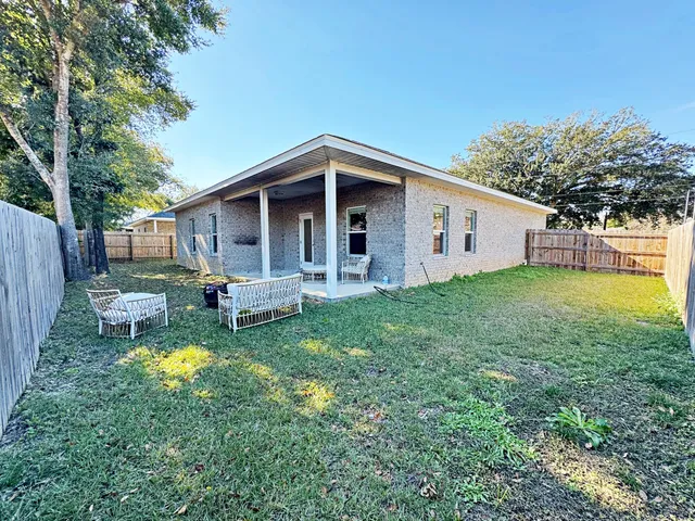 a view of a house with a yard and sitting area