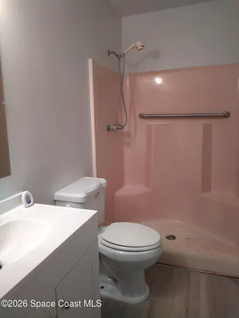 a bathroom with a toilet a sink and shower