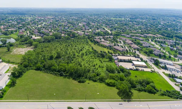 an aerial view of residential houses with outdoor space and trees