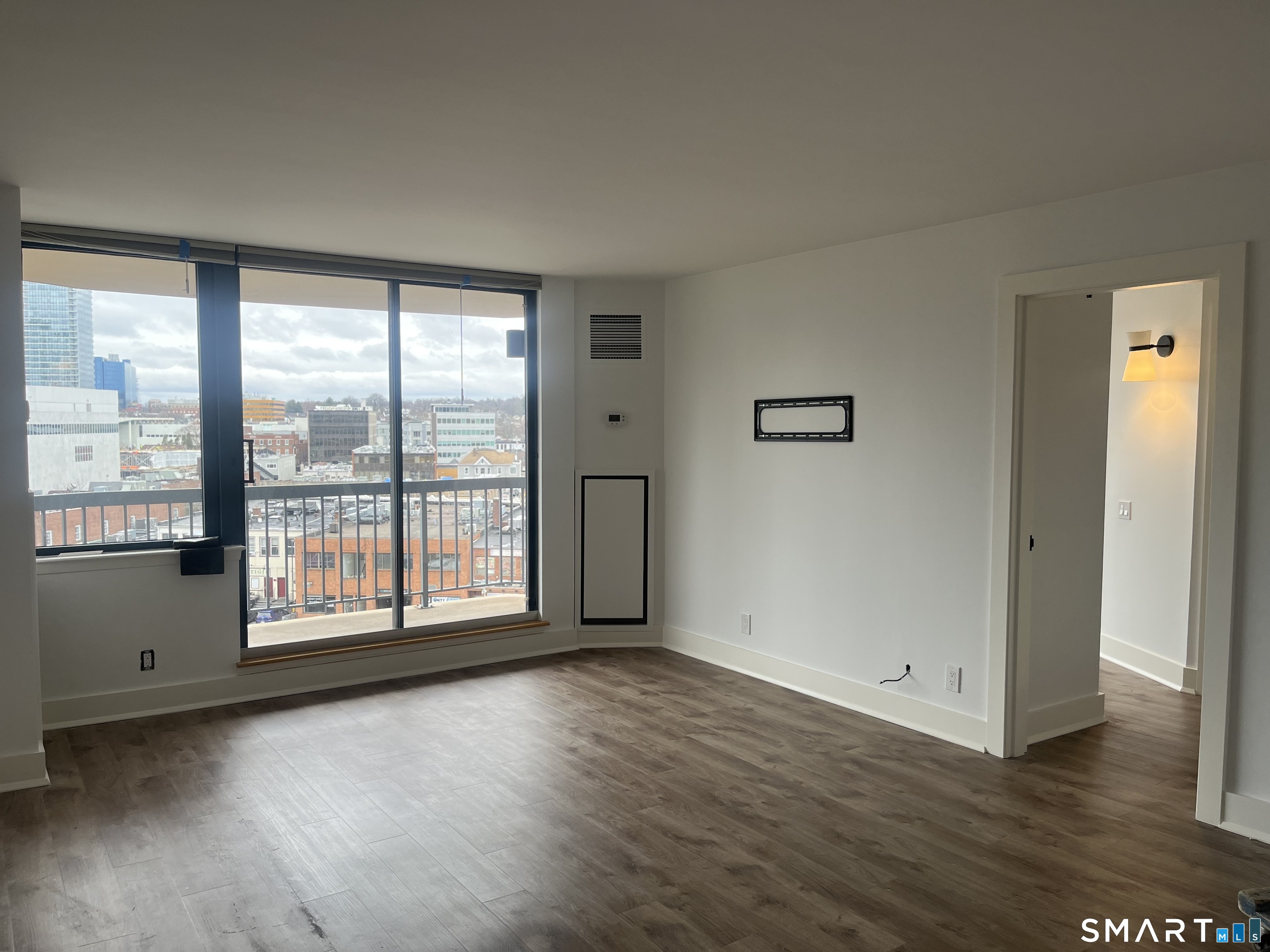 25 Forest Street, Unit 7K Stamford, CT 06901 - Photo 2 of 15 a view of an empty room with wooden floor and a window