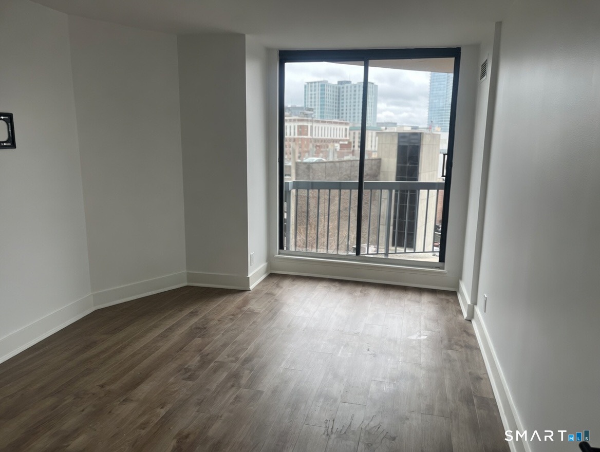 25 Forest Street, Unit 7K Stamford, CT 06901 - Photo 9 of 15 wooden floor in an empty room with a window