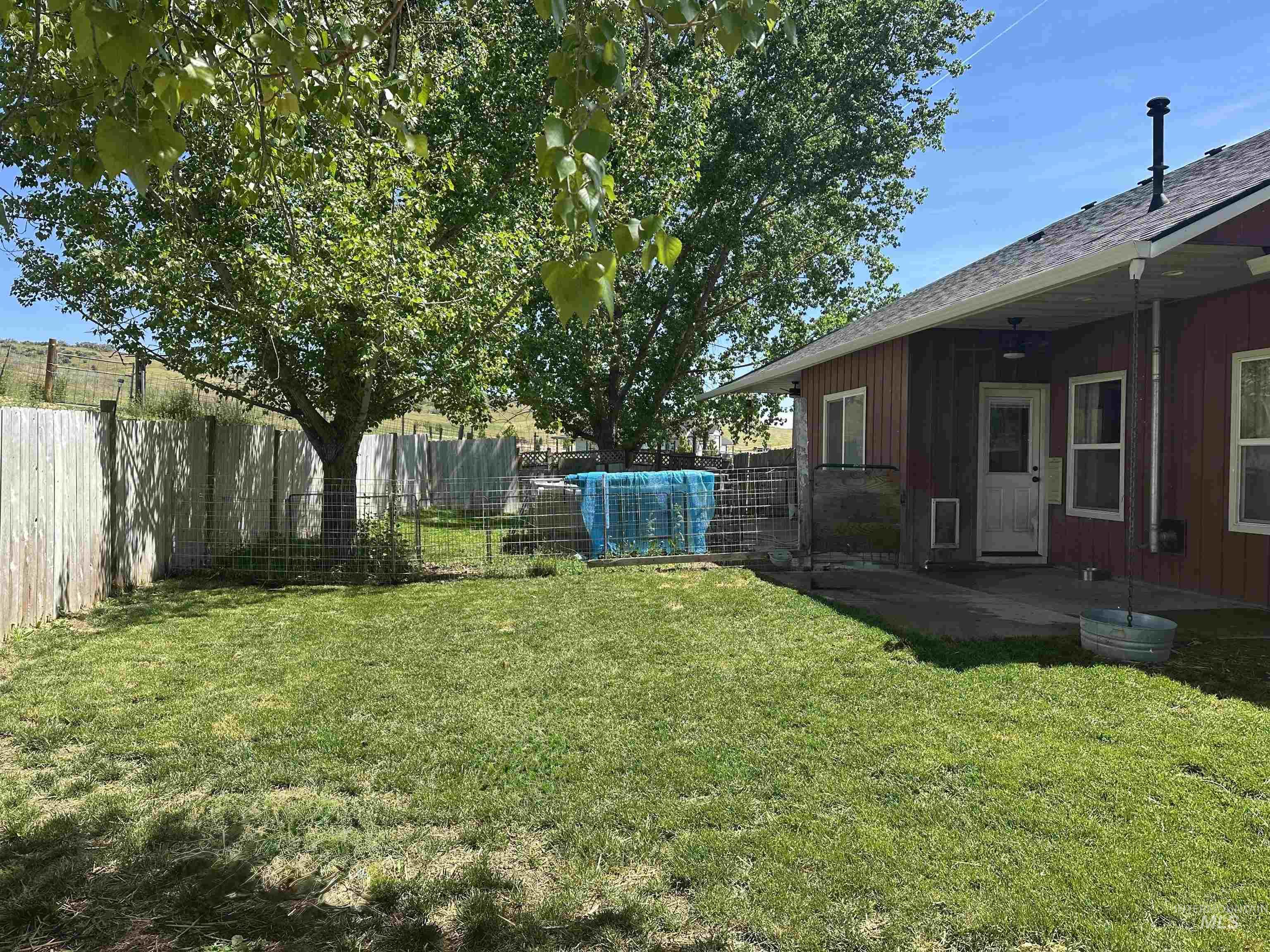 2580 Sand Hollow Road Caldwell, ID 83607 - Photo 48 of 50 Expansive backyard featuring a manicured lawn, mature trees, and a privacy fence