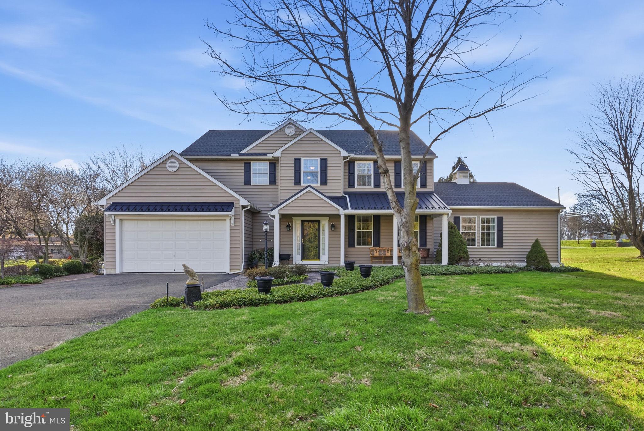 a front view of a house with a garden and trees