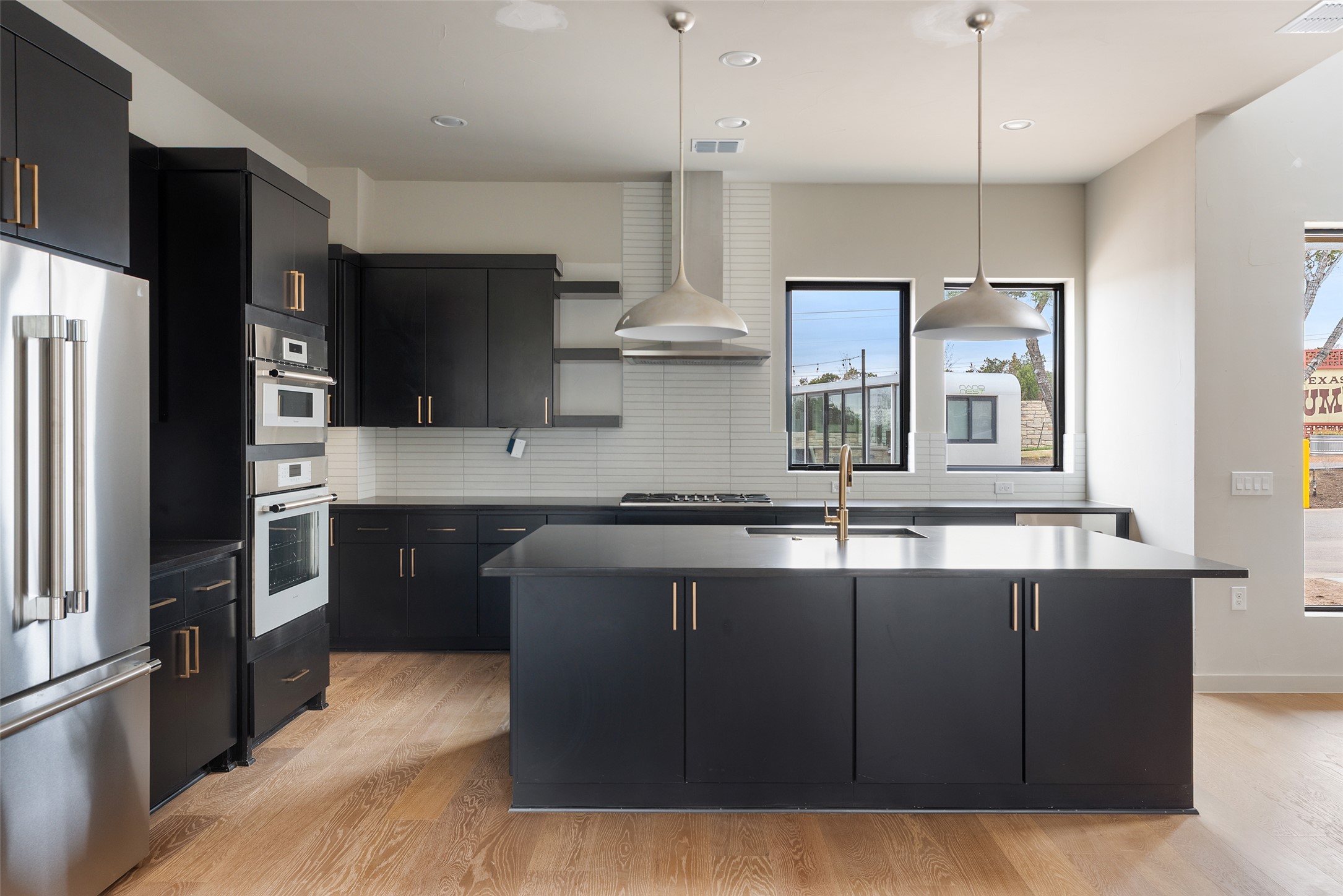 9803 Ribelin Ranch Court, Unit 10 Austin, TX 78750 - Photo 5 of 18 a kitchen with kitchen island granite countertop a sink stainless steel appliances and cabinets