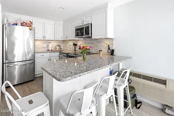 a kitchen with stainless steel appliances granite countertop a sink refrigerator and microwave