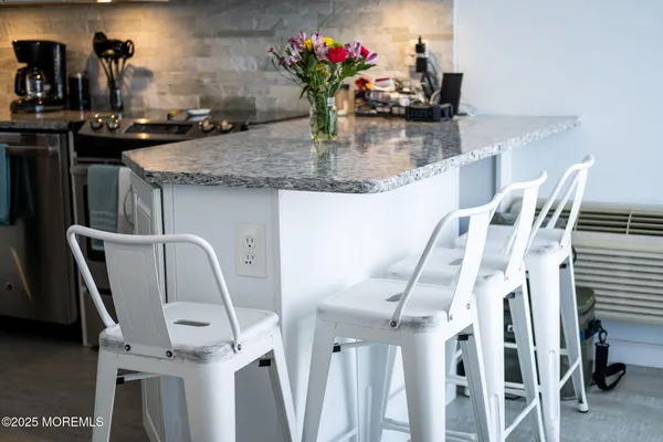 a kitchen with granite countertop white cabinets and white appliances