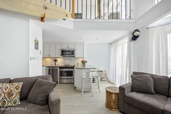 a living room with furniture and kitchen view