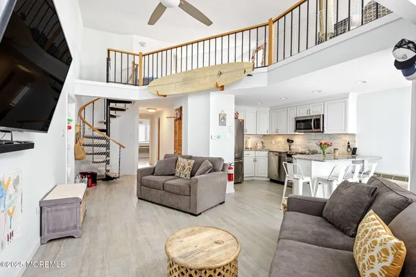 a living room with furniture kitchen view and a flat screen tv