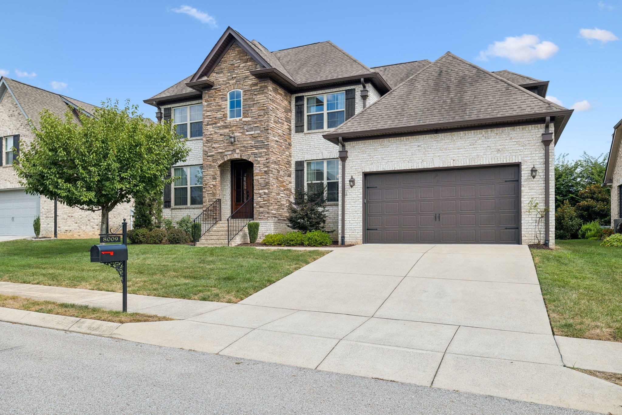 8009 June Apple Lane Spring Hill, TN 37174 - Photo 2 of 69 a front view of a house with a garden and trees