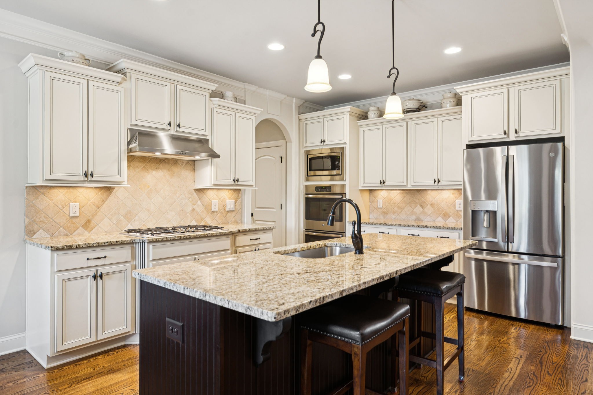 8009 June Apple Lane Spring Hill, TN 37174 - Photo 22 of 69 a kitchen with stainless steel appliances granite countertop a refrigerator a sink dishwasher a stove and white cabinets with wooden floor