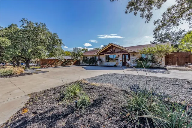 a front view of a house with a yard and trees