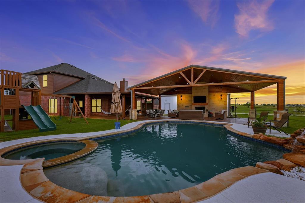 430 Ridgecrest Place Sanger, TX 76266 - Photo 2 of 40 Expansive outdoor entertaining area featuring a freeform swimming pool with integrated spa and rock waterfall