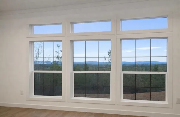 a view of an empty room with wooden floor and cabinet