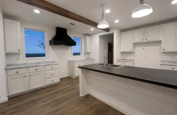 a spacious bathroom with a granite countertop toilet a sink and a mirror